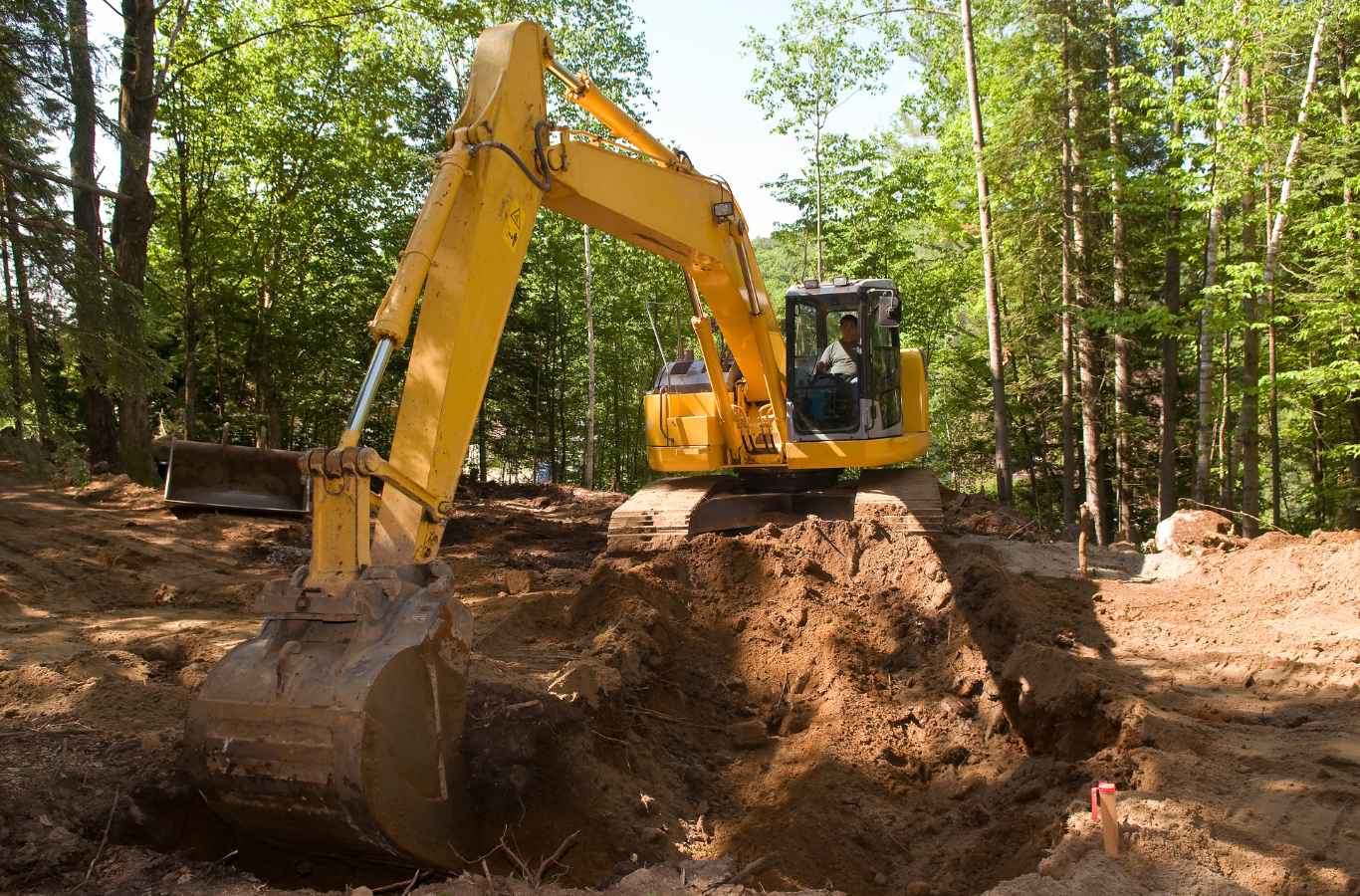 Excavation work underway by Painter Land Development at a Lake Keowee site, showcasing heavy machinery in a natural setting.