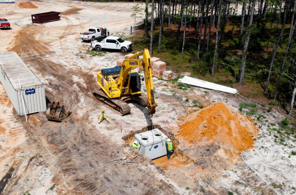 Benefits of land grading and excavation in Cashiers, NC by Painter Land Development. A team preparing a large plot for building with heavy equipment.